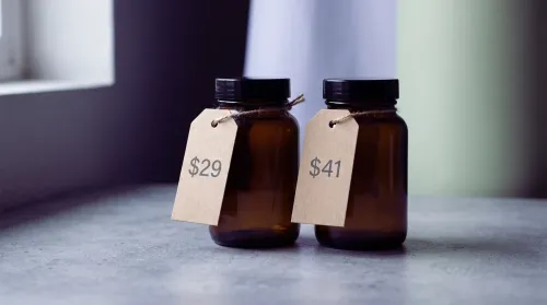 Two identical unlabeled wellness bottles side by side, each with its own price tag, a fair pricing comparison